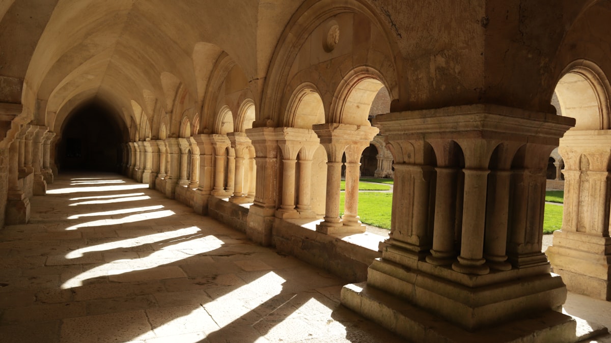 a long hallway with stone pillars and arches