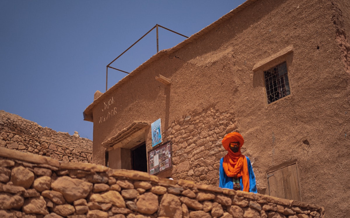 A stone wall with a building in the background