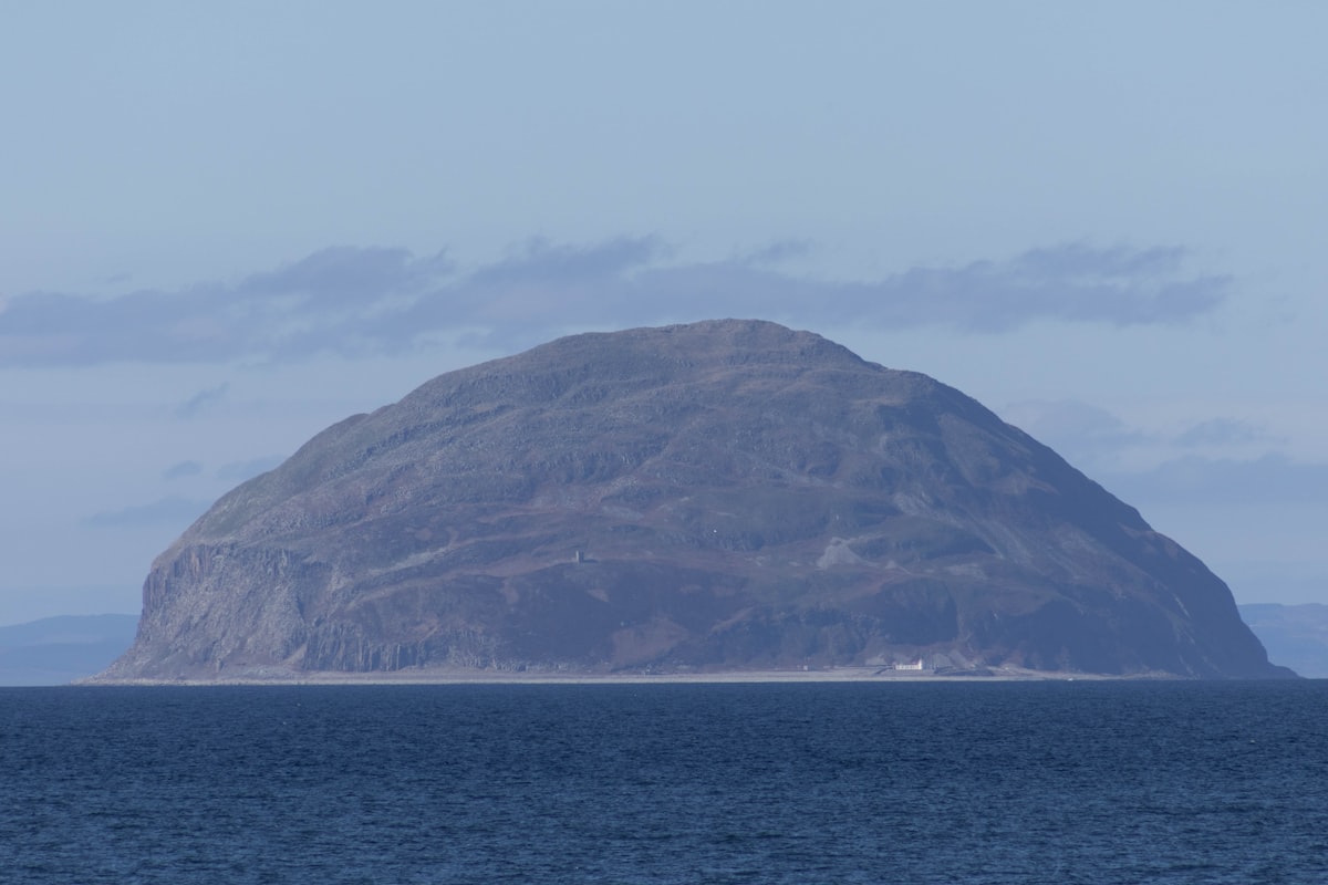 A large, rocky island sits in the ocean.
