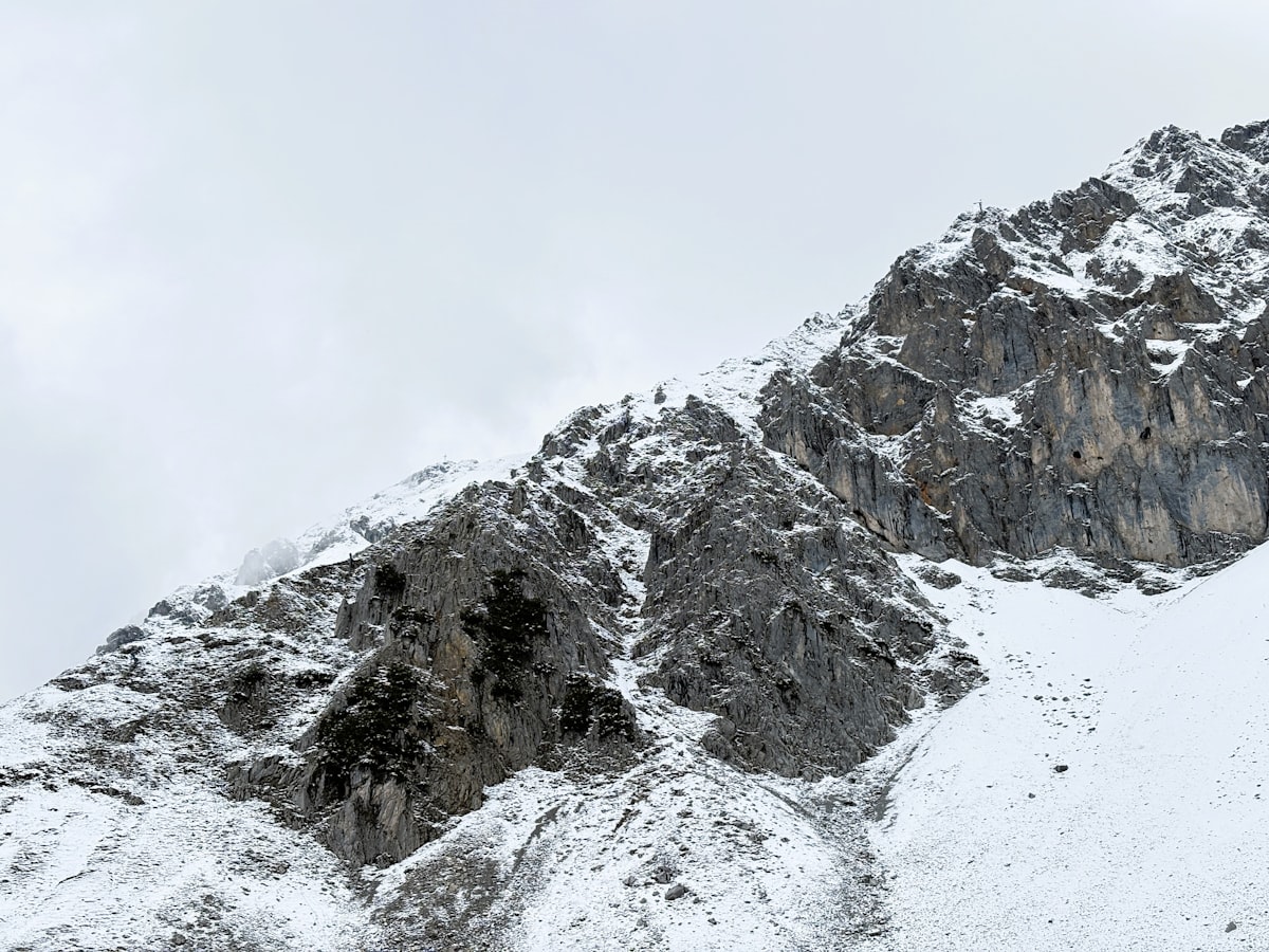 Snowy mountains rise under a cloudy sky.