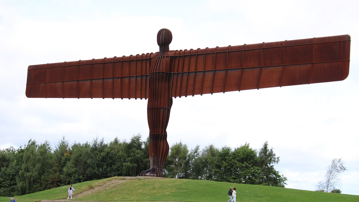 A large metal angel statue on top of a hill