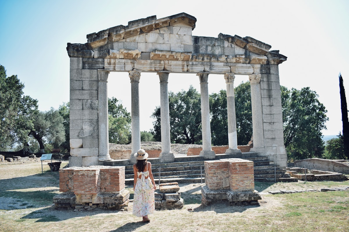 A woman standing in front of a stone structure
