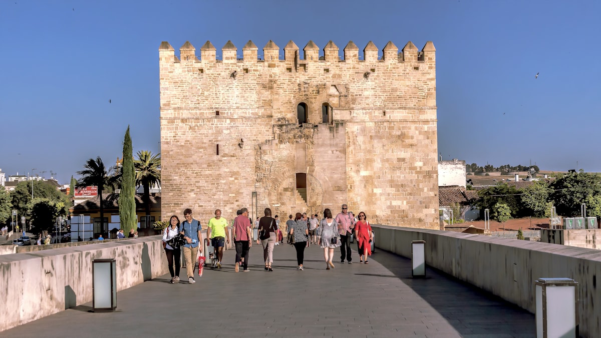 a group of people walking across a bridge