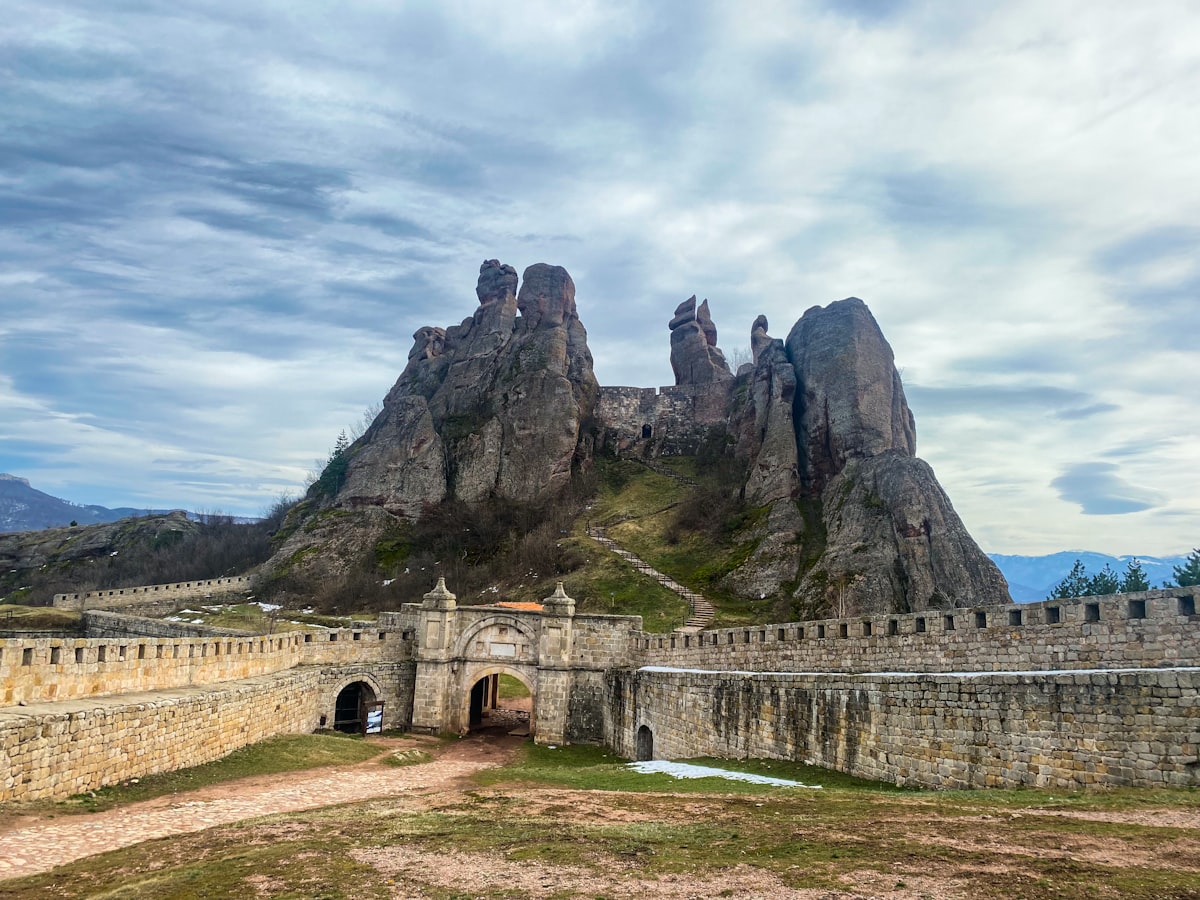 a stone castle with a mountain in the background