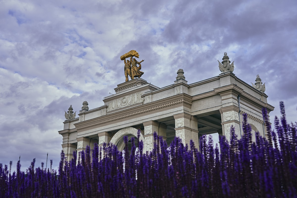 white concrete building under white clouds during daytime