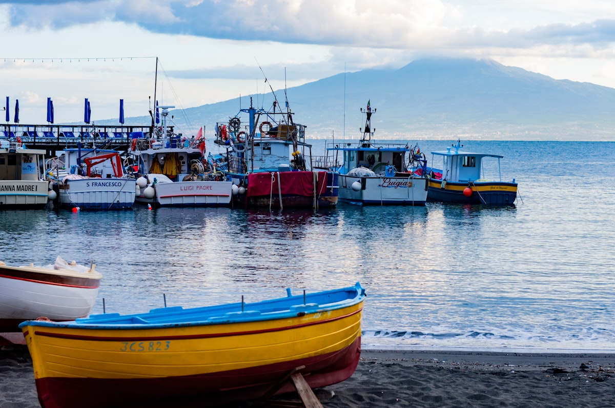red and yellow boat on sea shore during daytime