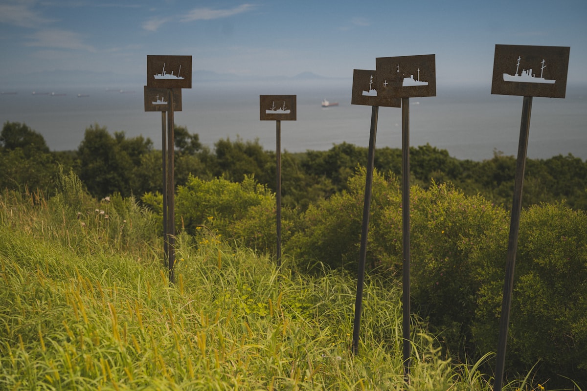 Metal signs with ship icons on poles overlooking water