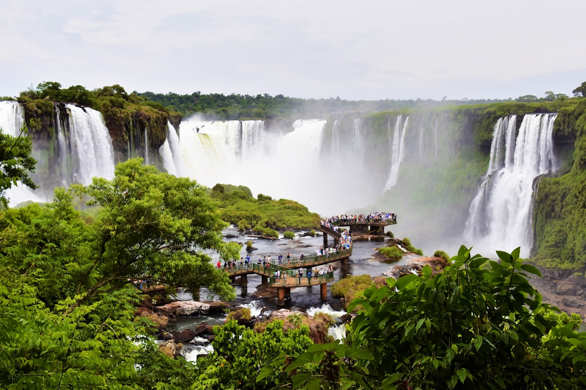 a view of a waterfall with a bridge in the foreground