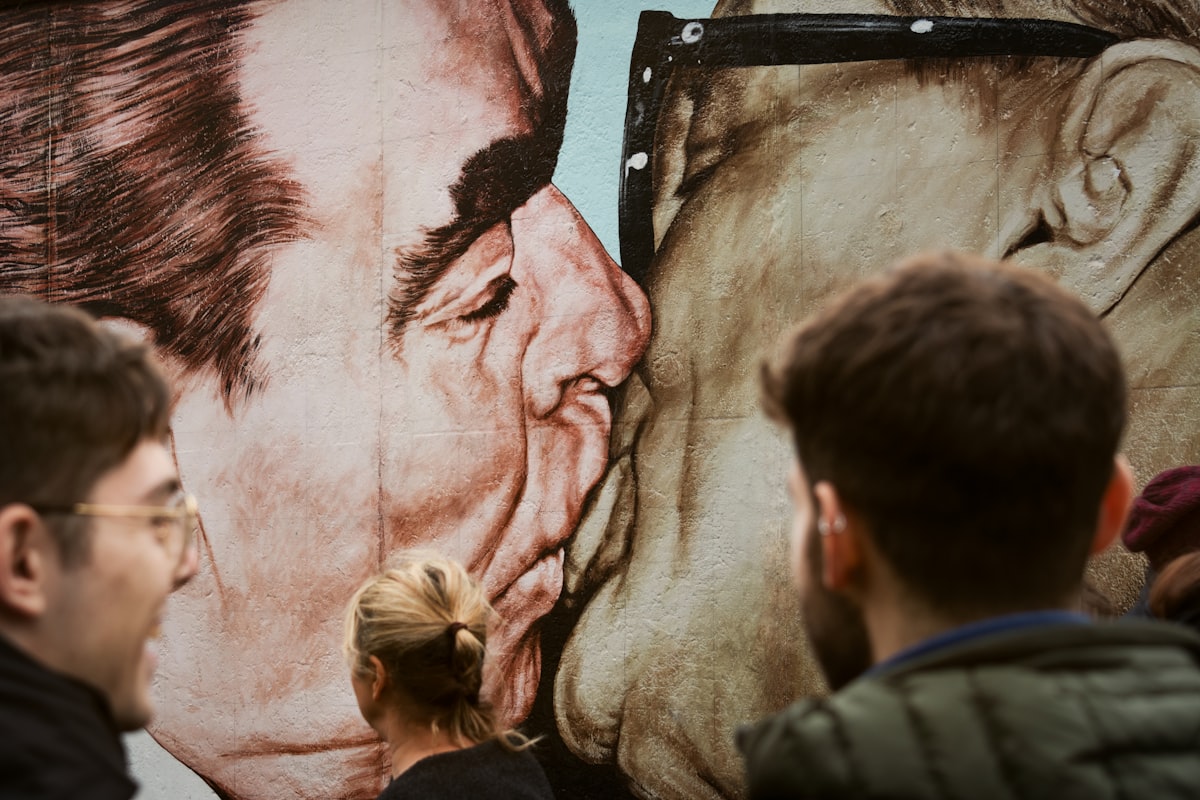a group of people standing in front of a painting of a man and woman