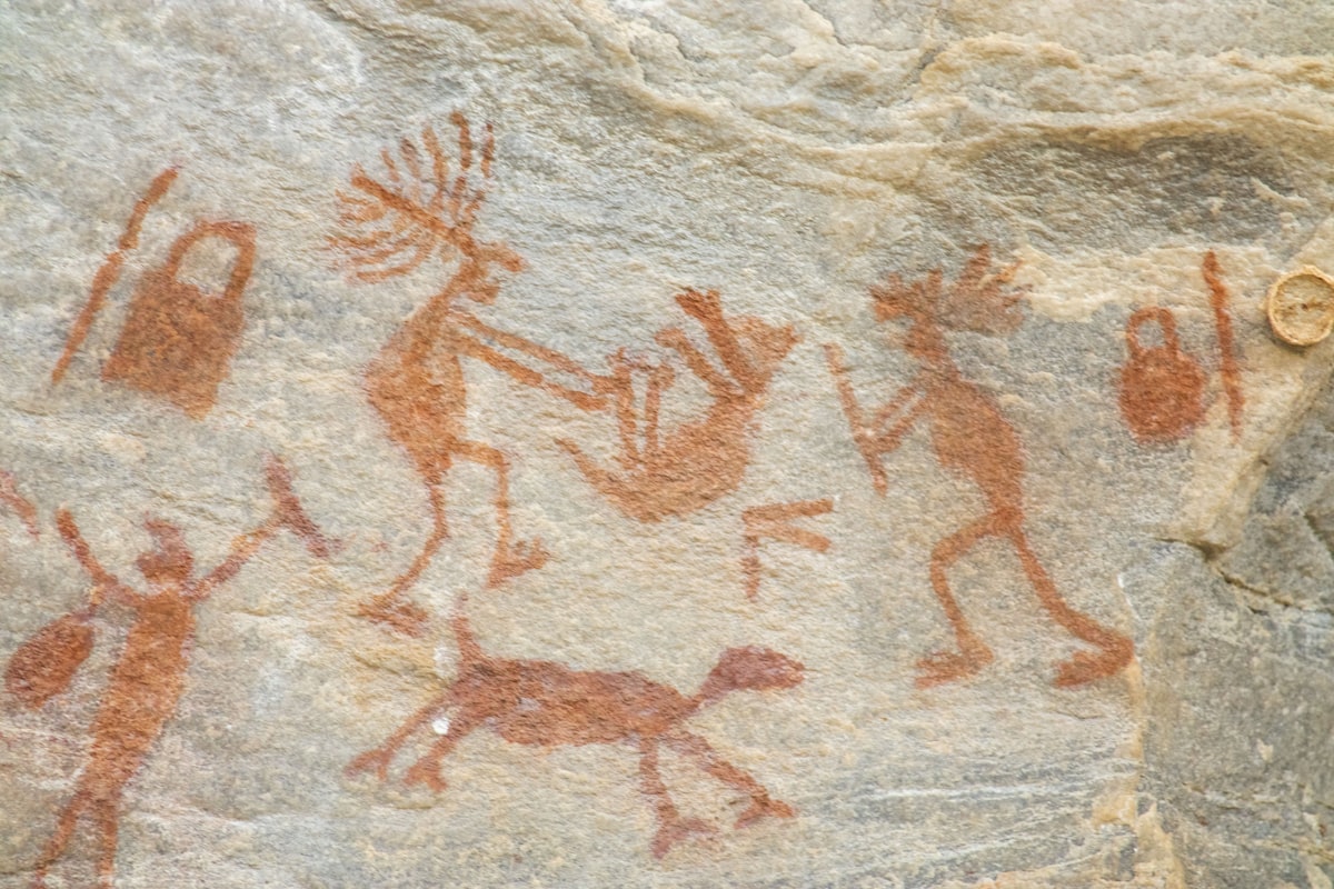 a rock painting of people and animals on it