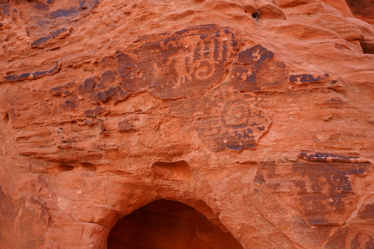 Ancient petroglyphs carved into a sandstone cliff.