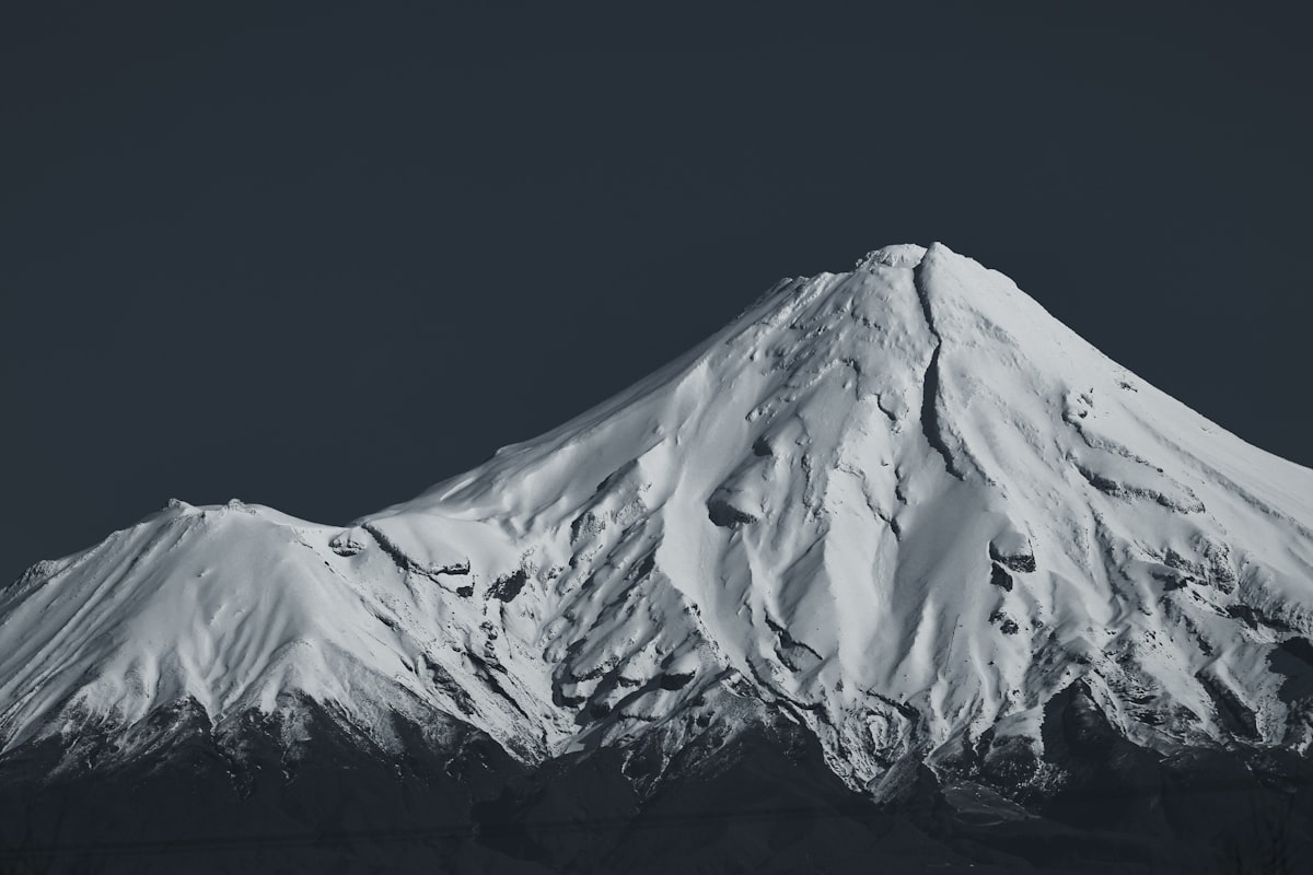 Snow-covered mountain peak against dark sky