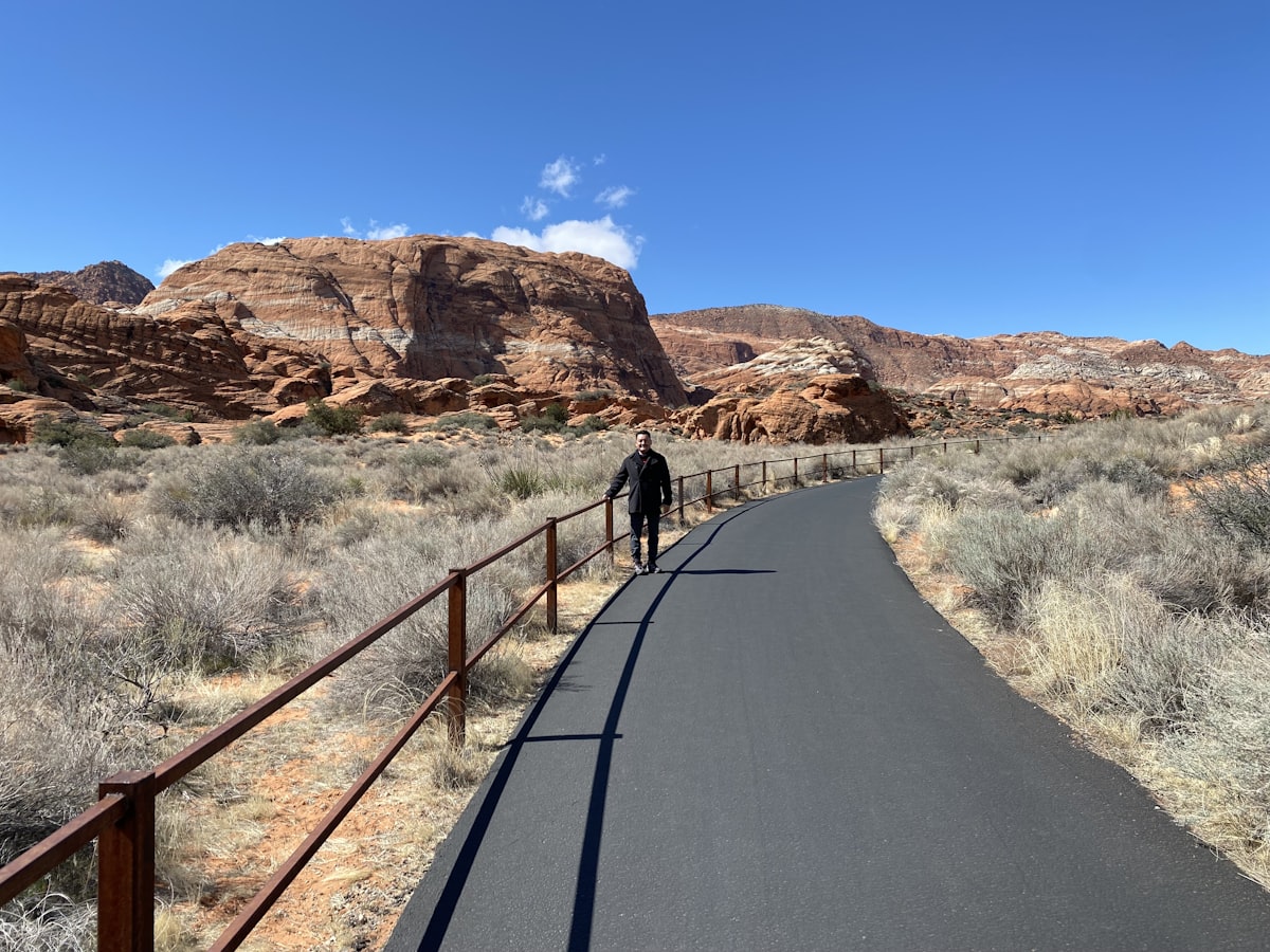 a man riding a skateboard down a paved road