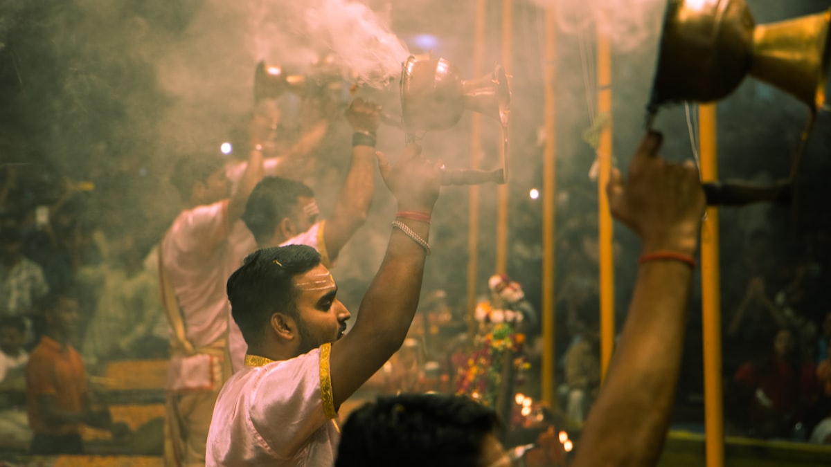 People performing a ritual with smoke and bells