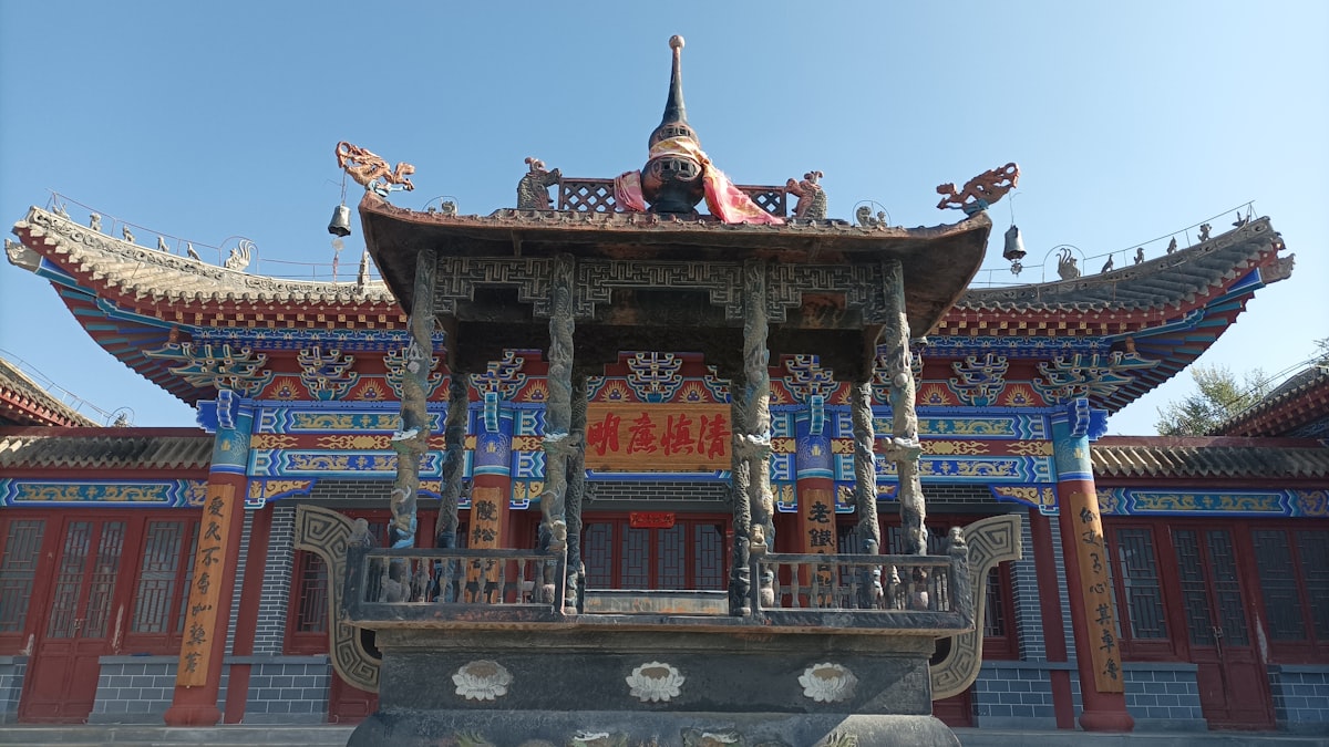 a chinese building with a statue on top of it