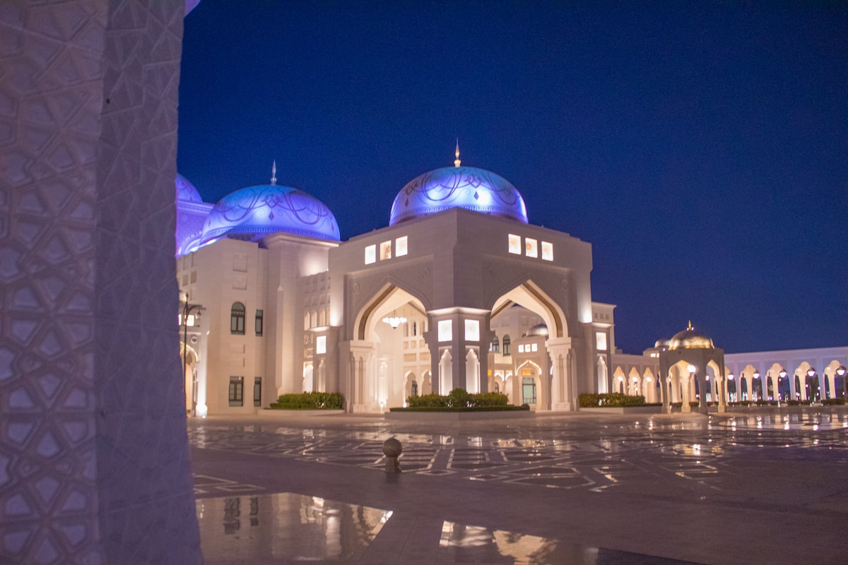 a large white building with blue domes at night