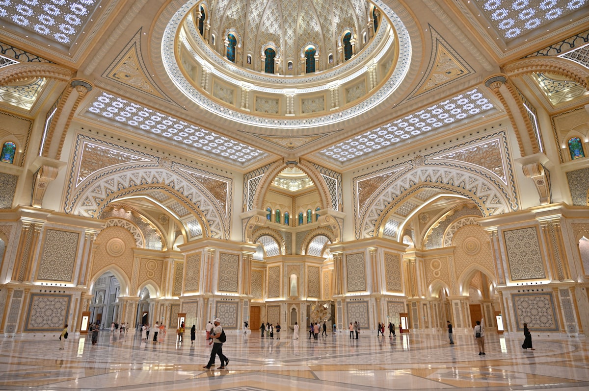 Ornate interior of a grand palace with people walking