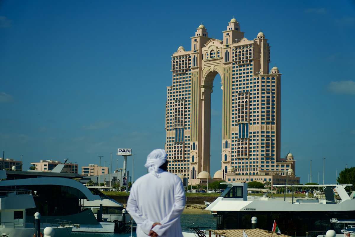 Man in traditional clothing looks at modern skyscraper