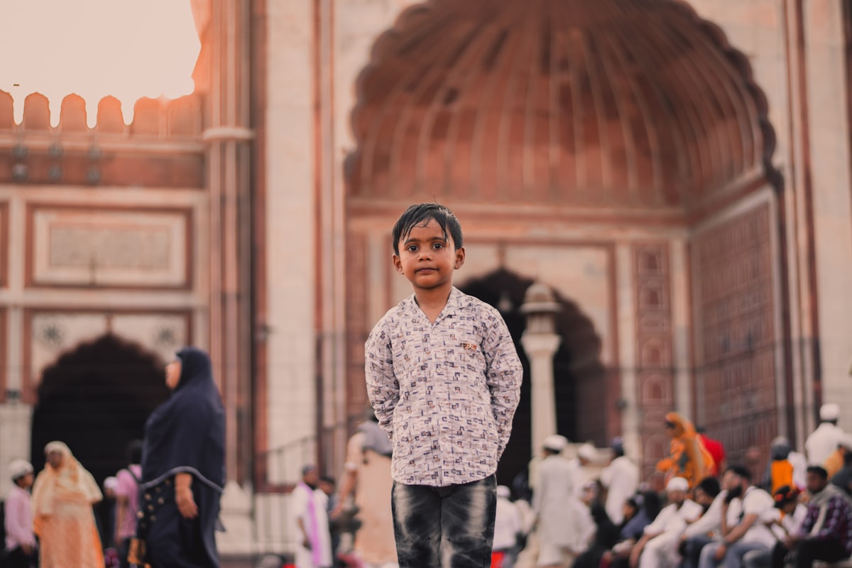 a young boy standing in front of a building