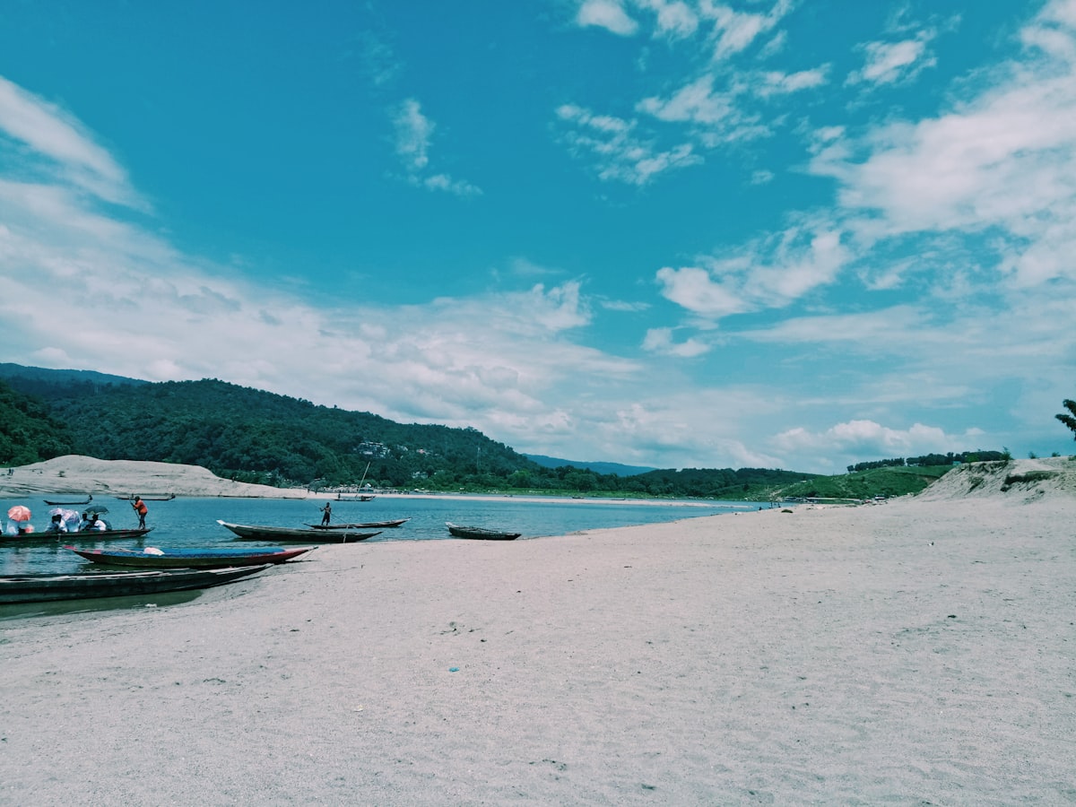 white boat on sea shore during daytime