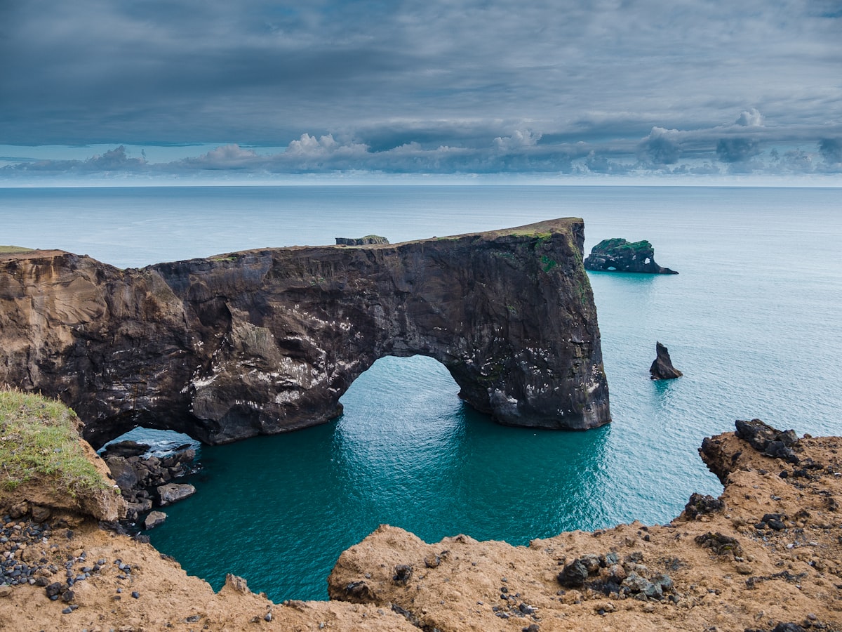 brown rock formation on blue sea under blue sky during daytime