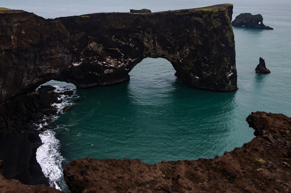 brown rock formation on blue sea during daytime