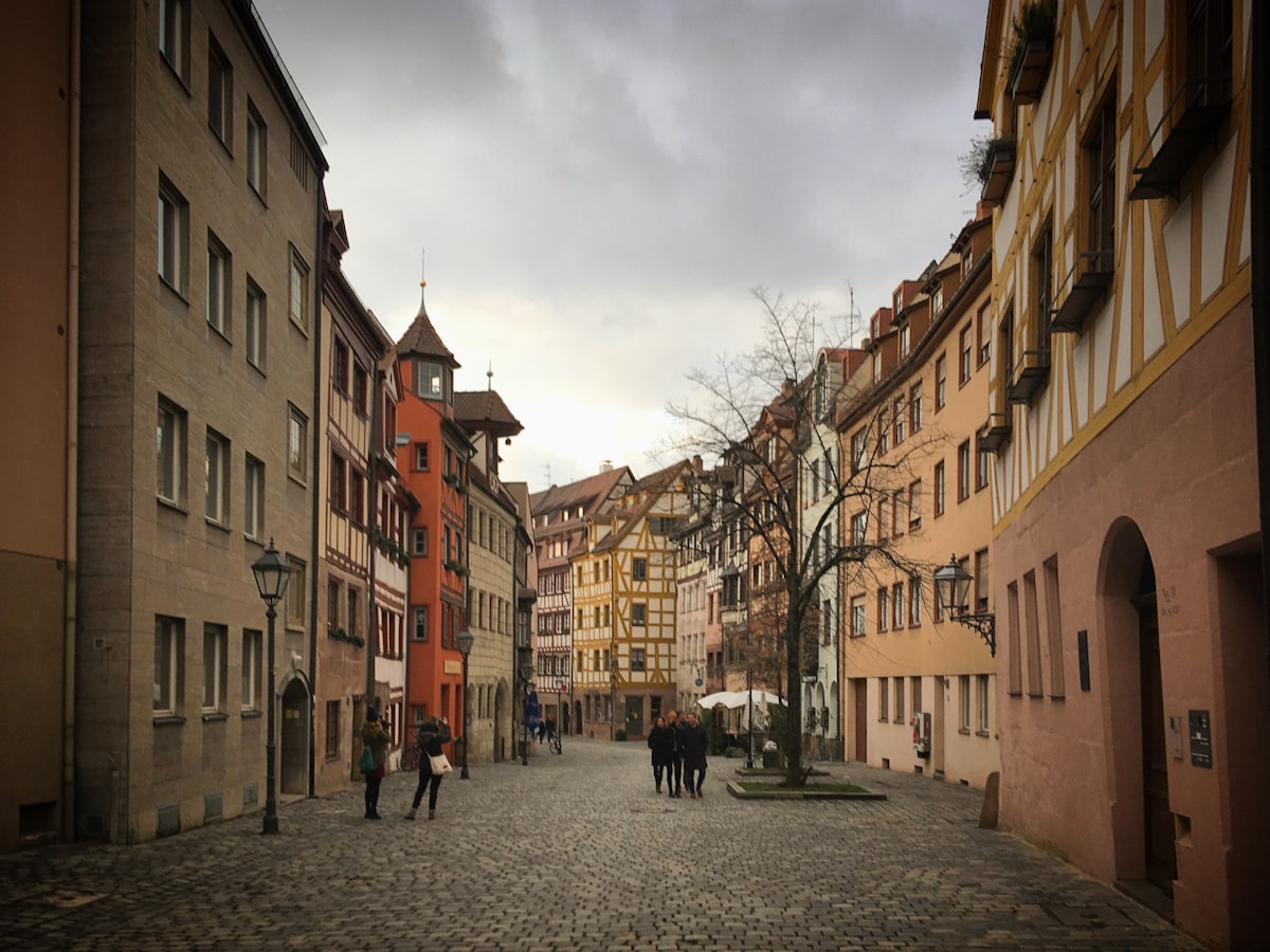 a group of people walking down a cobblestone street