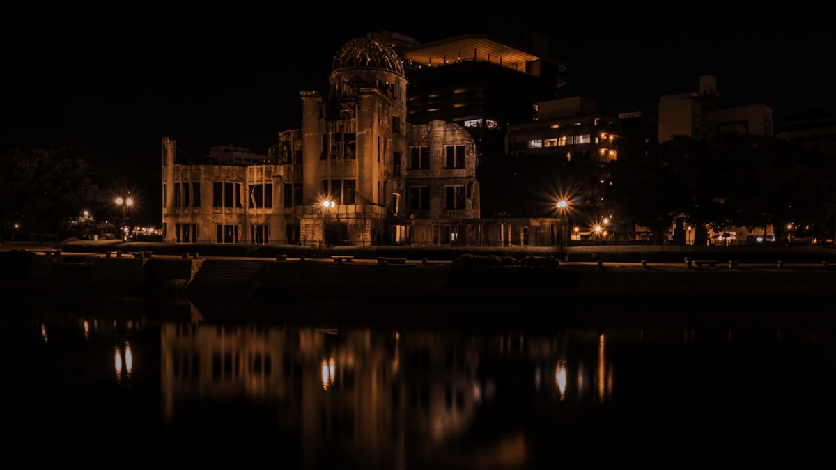 brown concrete building near body of water during night time
