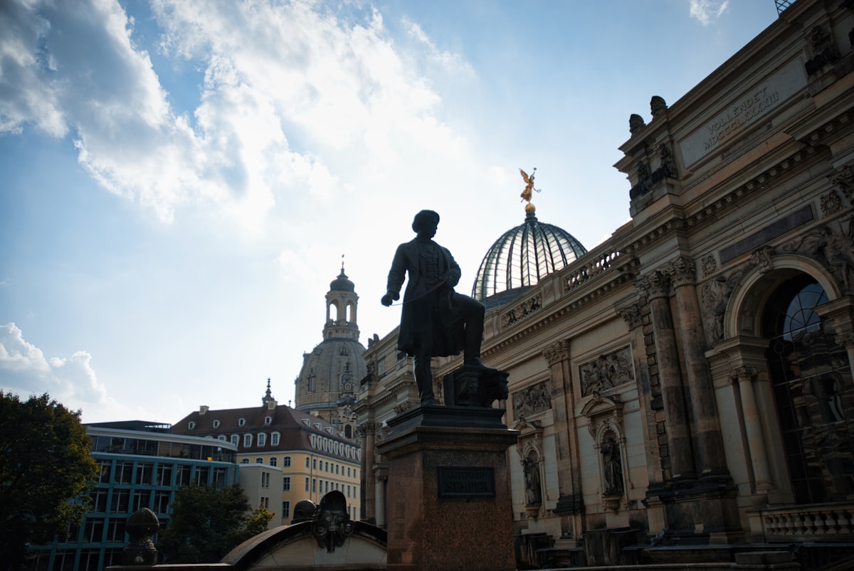 Statue in front of historic building with dome.