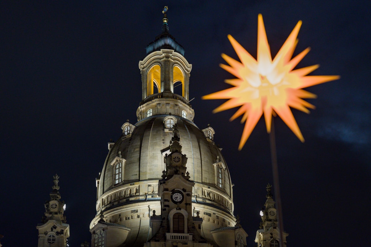 Gleaming star decoration near illuminated church dome at night