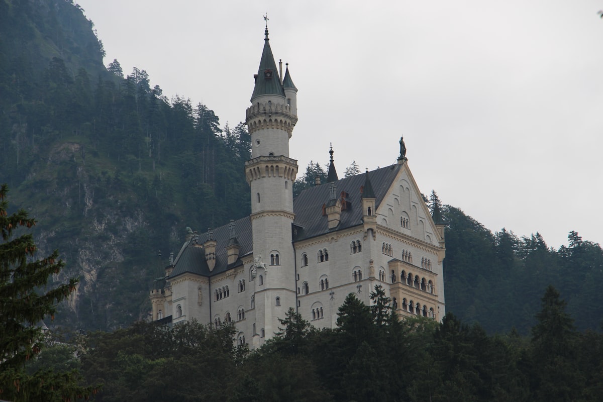 white and gray concrete castle surrounded by green trees during daytime
