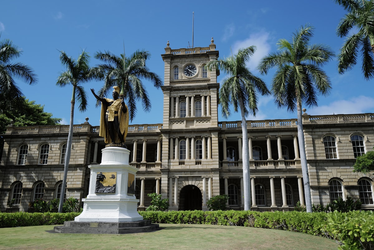 a statue in front of a large building with a clock tower