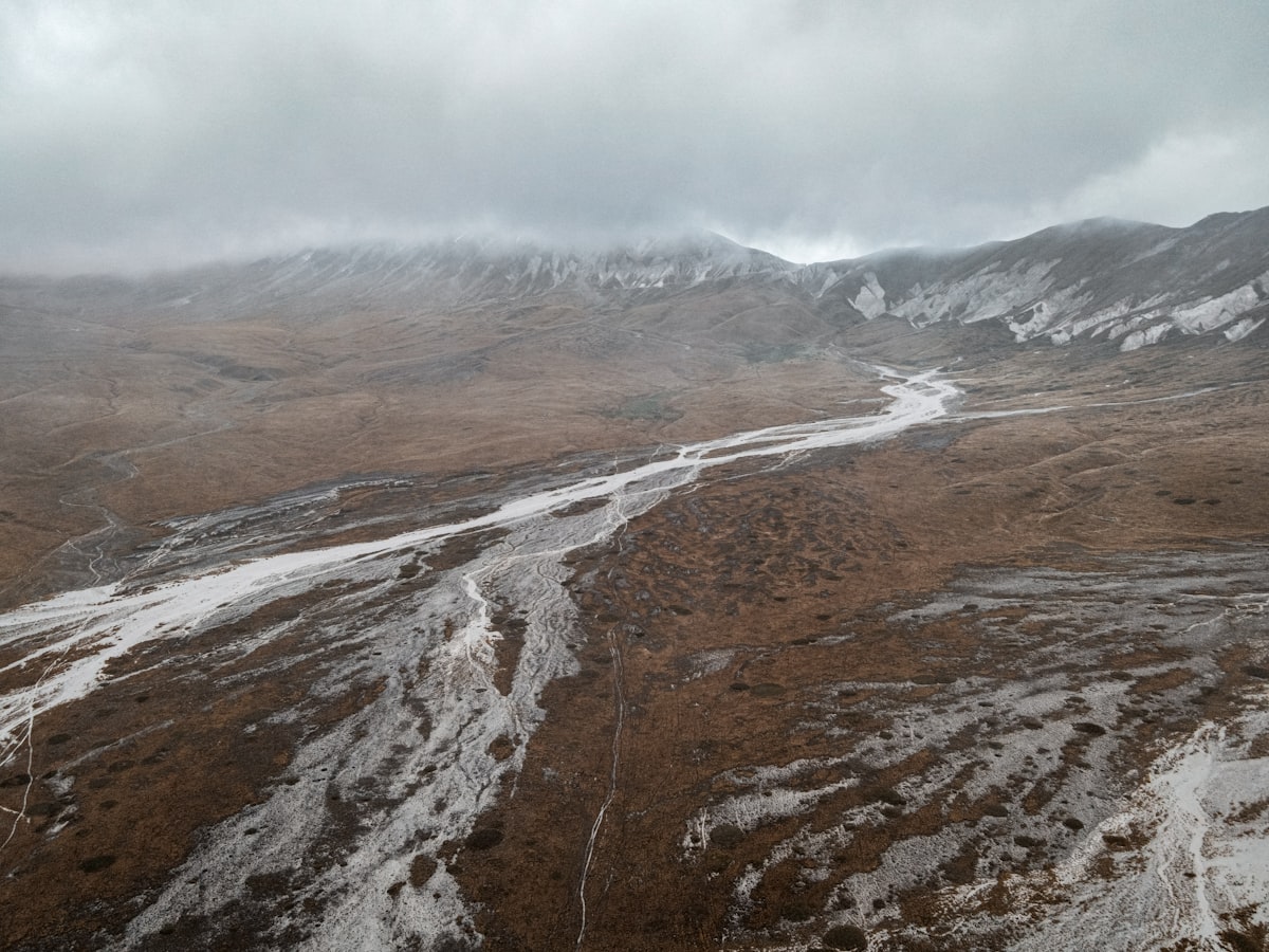 brown and white mountains under white clouds during daytime