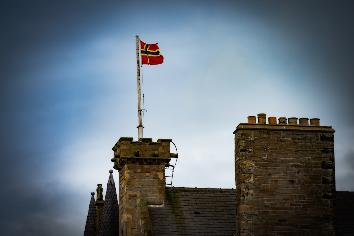 Red flag flies atop a stone building