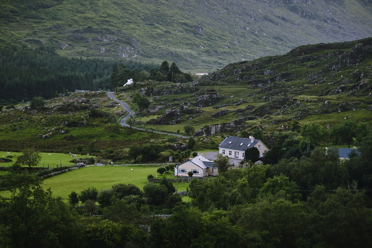 a house in the middle of a lush green valley