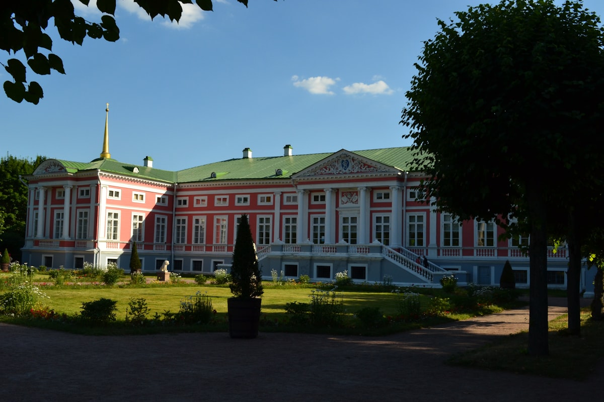 a large red and white building with a green roof