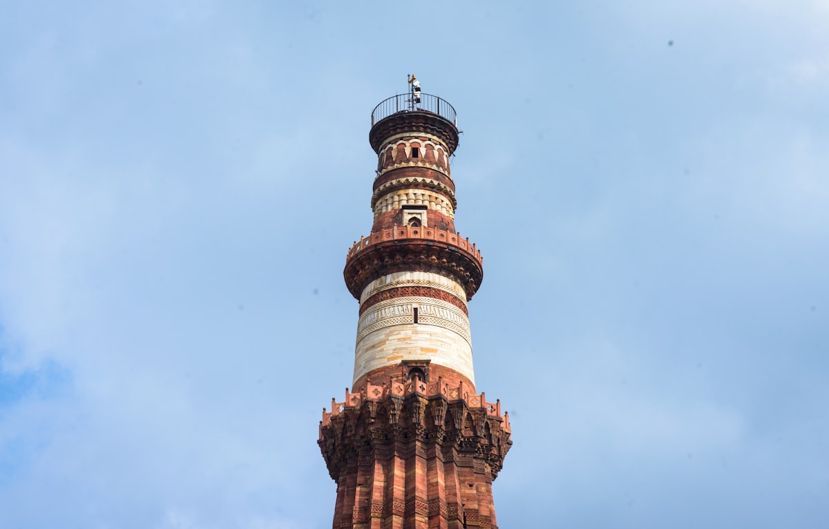 Tall historic tower against a cloudy blue sky