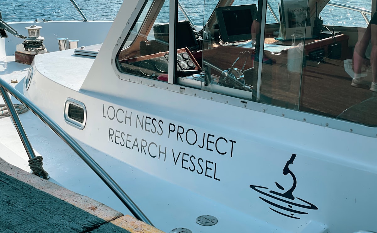 a white boat with a black logo on it