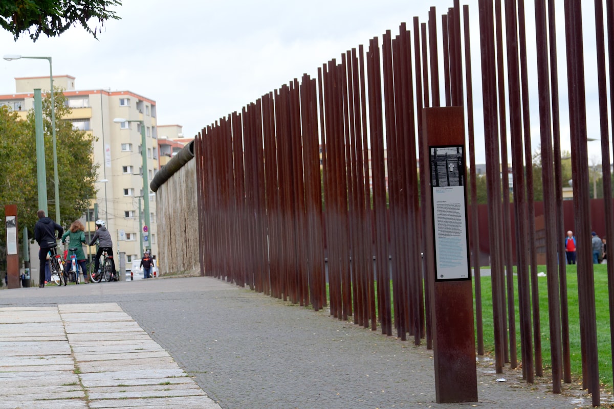 a group of people standing next to a metal fence