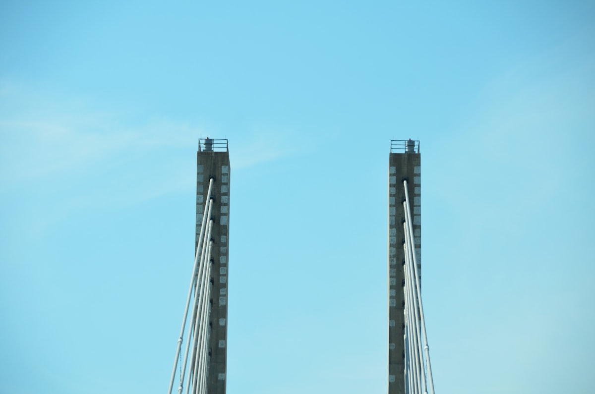 A traffic light on a bridge with a blue sky in the background