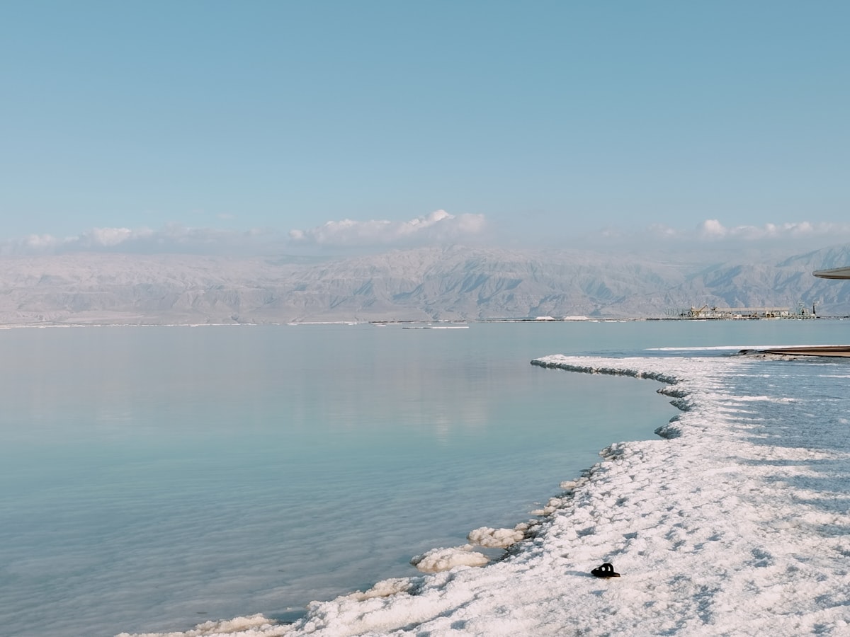 a body of water surrounded by snow and mountains