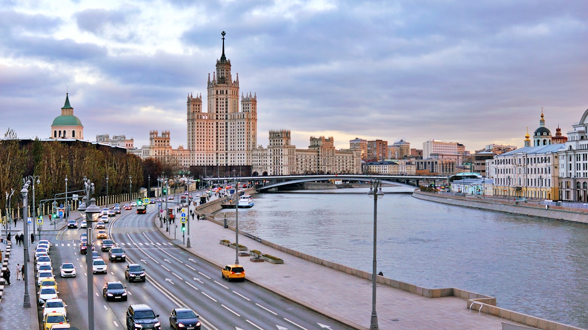 Moscow skyline features a river and grand architecture.
