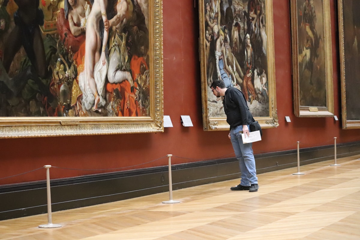 Man looking at paintings in a museum