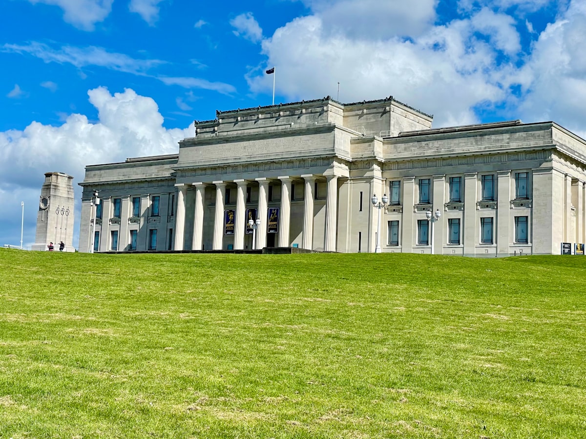 A large white building sitting on top of a lush green field