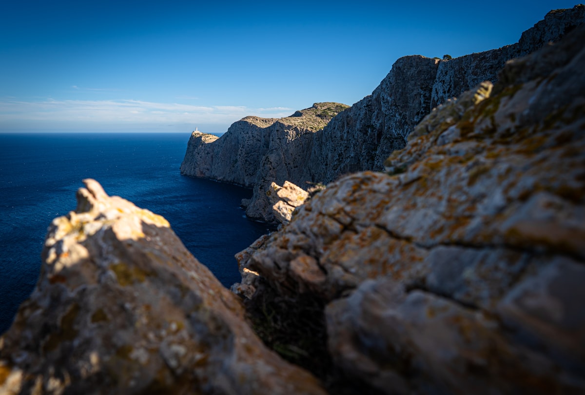 a rocky cliff with a body of water in the background