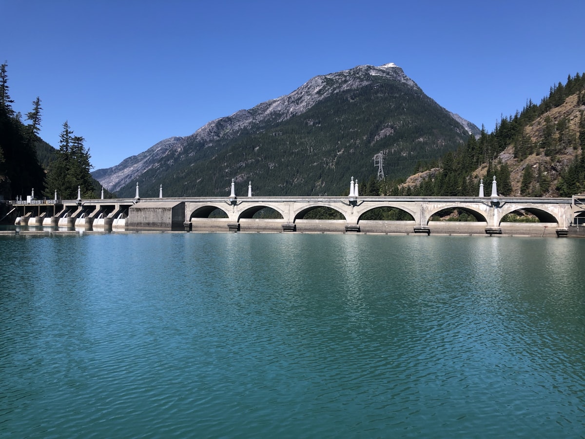 a bridge over a body of water with mountains in the background