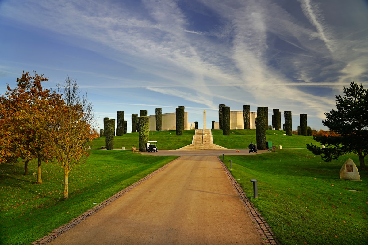 a dirt road going through a lush green park