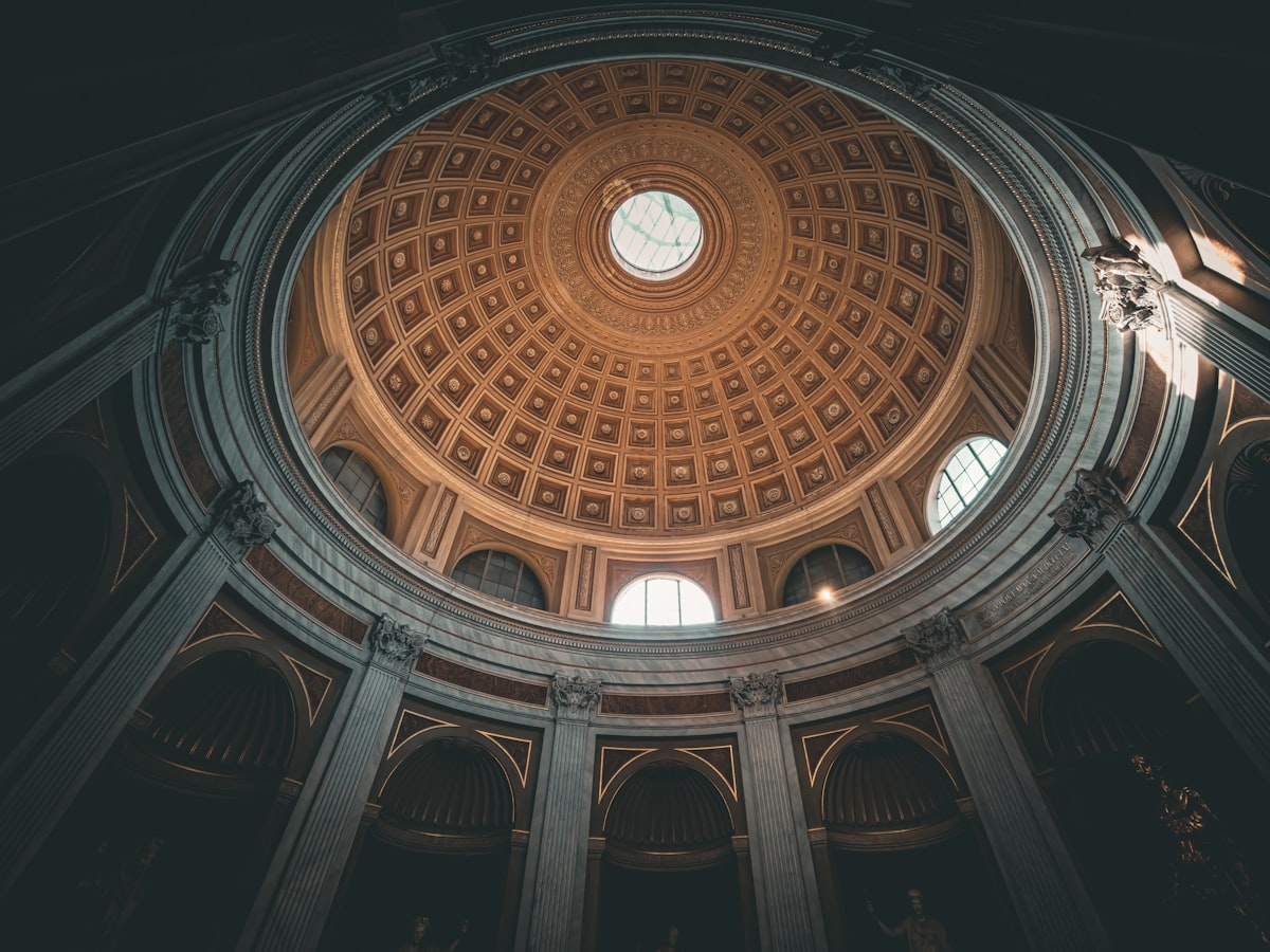 Looking up at a grand domed ceiling with windows.