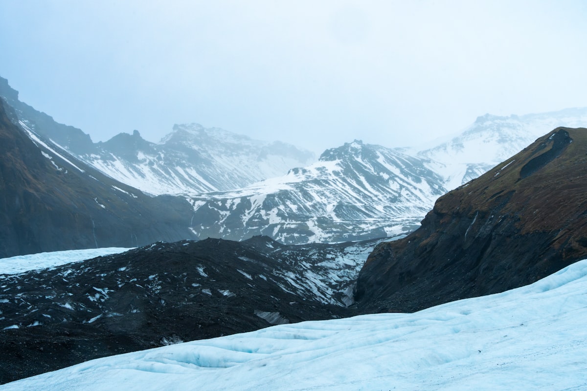 Snowy mountains and glacier under a misty sky