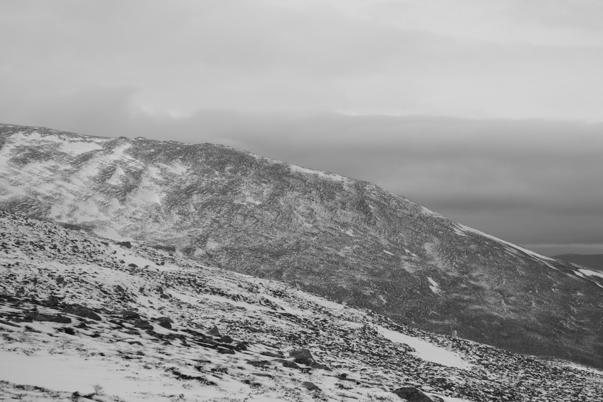 a black and white photo of a snow covered mountain